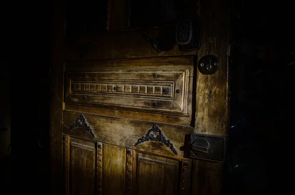 Vista de cerca de la antigua puerta de madera antigua dentro de la habitación oscura. Enfoque selectivo — Foto de Stock