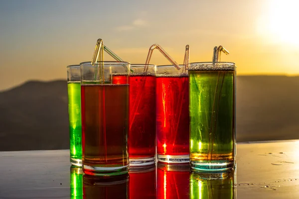 Kühlendes Sommergetränk. Cocktailgläser plätschern bei Sonnenuntergang. Nahaufnahme nasses Glas kaltes Getränk auf der Terrasse. — Stockfoto