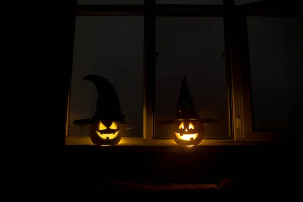 Citrouille d'Halloween effrayant dans la fenêtre de la maison mystique la nuit ou citrouille d'Halloween la nuit sur la chambre avec fenêtre bleue. Symbole d'Halloween dans la fenêtre . — Photo