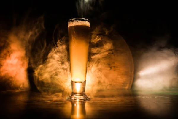 Conceito criativo. copos de cerveja na mesa de madeira no fundo enevoado tonificado escuro . — Fotografia de Stock