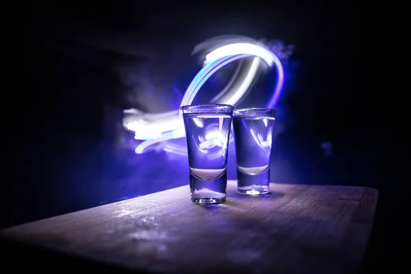 Концепція клубного напою. Смачний алкоголь п'ють коктейль текіла з лаймом і сіллю на яскравому темному фоні або келихах з текілою в барі — стокове фото