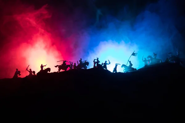 Scène de bataille médiévale avec cavalerie et infanterie. Silhouettes de figures comme objets séparés, combat entre guerriers sur fond brumeux sombre avec château médiéval . — Photo