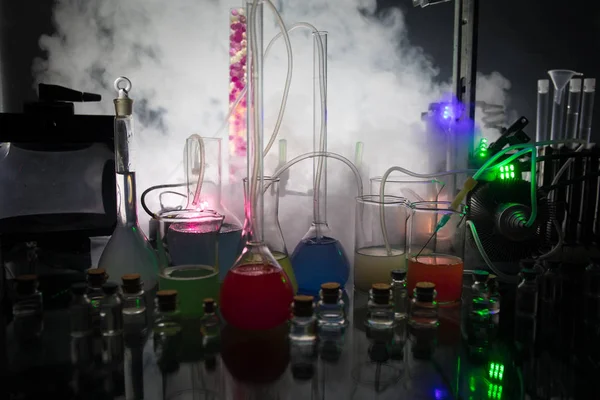 Eczacılık ve kimya teması. Araştırma laboratuvarında solüsyon lu cam şişesi test edin. Bilim ve tıbbi geçmiş. Koyu tonlu arka plan üzerinde laboratuvar test tüpleri