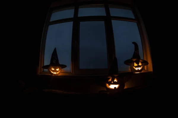 Gruseliger Halloween-Kürbis in der Nacht im mystischen Hausfenster oder Halloween-Kürbis in der Nacht auf Zimmer mit blauem Fenster. Symbol von halloween im Fenster. — Stockfoto