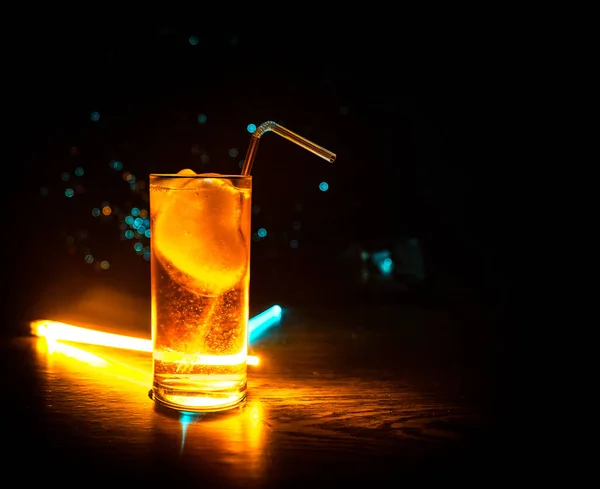 Cocktail glas spetteren op donkere toned rokerige achtergrond of kleurrijke cocktail in glas. Party Club entertainment. Gemengd licht. — Stockfoto