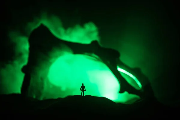 Décoration d'art avec os d'animal. Silhouette dans une crypte souterraine abandonnée. homme debout devant une entrée de grotte — Photo