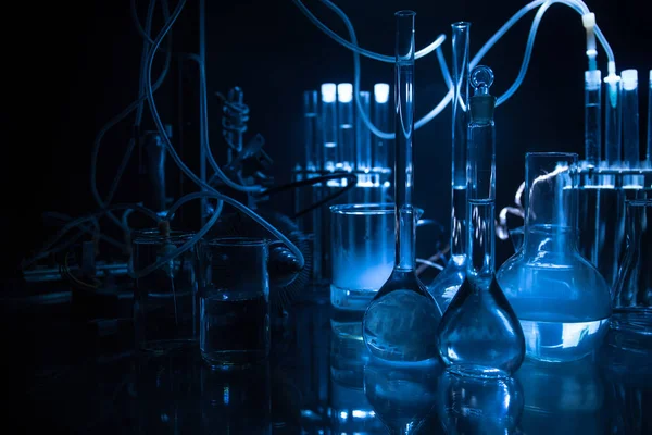 Pharmacy and chemistry theme. Test glass flask with solution in research laboratory. Science and medical background. Laboratory test tubes on dark toned background — Stock Photo, Image