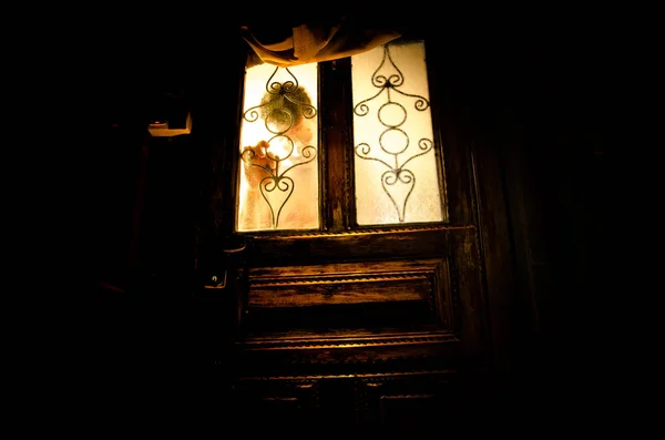 一个未知的影子人物在一个旧木门通过一个封闭的玻璃门的剪影。夜晚在窗前的人的剪影. — 图库照片
