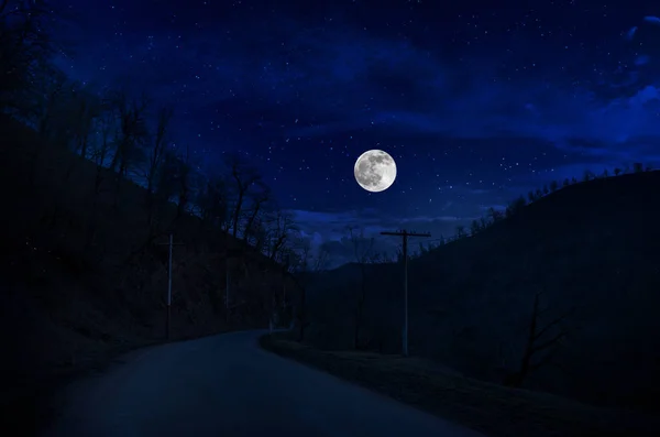 Mountain Road a través del bosque en una noche de luna llena. Paisaje nocturno escénico de carretera rural por la noche — Foto de Stock