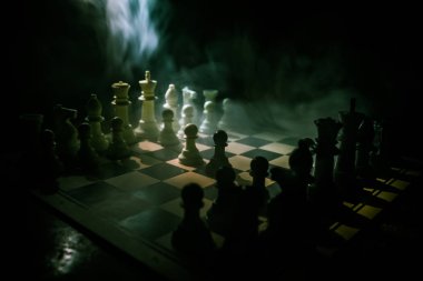 İş fikirleri ve rekabet Satranç tahtası oyun kavramı. Duman ve sis ile karanlık bir arka plan üzerinde Satranç rakamlar.