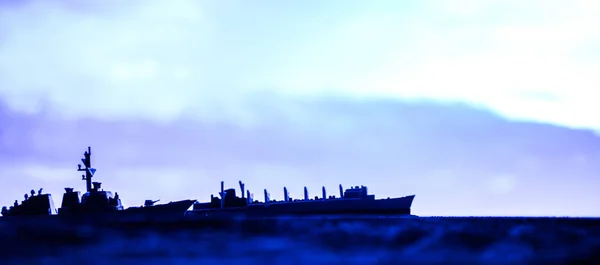 Sotilaslaivaston aluksia merenlahdella auringonlaskun aikaan. Valikoiva painopiste — kuvapankkivalokuva