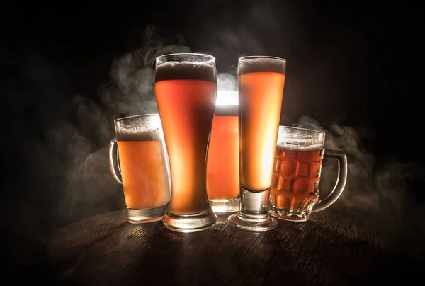 Concepto creativo. Vasos de cerveza sobre mesa de madera en fondo nebuloso tonificado oscuro . — Foto de Stock