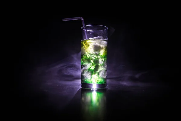 Cocktail vidro espirrando sobre fundo fumado tonificado escuro ou coquetel colorido em vidro. Entretenimento do clube de festas. Luz mista . — Fotografia de Stock