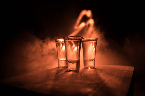 Concepto de bebida del club. Bebida alcohólica sabrosa cóctel de tequila con lima y sal sobre fondo oscuro vibrante o vasos con tequila en un bar — Foto de Stock