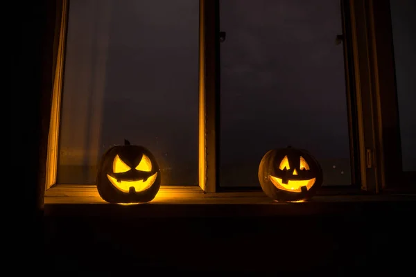 Страшный Хэллоуин тыква в мистическом окне дома ночью или Хэллоуин тыква ночью в комнате с голубым окном. Символ Хэллоуина в окне . — стоковое фото
