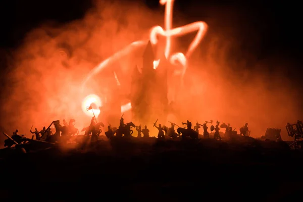 Escena de batalla medieval con caballería e infantería. Siluetas de figuras como objetos separados, lucha entre guerreros sobre fondo nebuloso tonificado oscuro con castillo medieval . — Foto de Stock