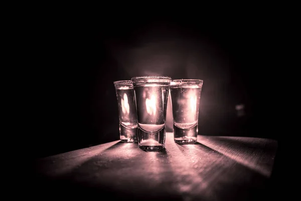 Concepto de bebida del club. Bebida alcohólica sabrosa cóctel de tequila con lima y sal sobre fondo oscuro vibrante o vasos con tequila en un bar — Foto de Stock