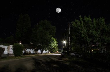 Gece oldukça köy üzerinde dolunay. Işıklar ile eski şehir caddesi güzel gece manzara. Rusya
