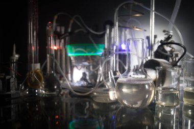 Eczacılık ve kimya teması. Araştırma laboratuvarında solüsyon lu cam şişesi test edin. Bilim ve tıbbi geçmiş. Koyu tonlu arka plan üzerinde laboratuvar test tüpleri