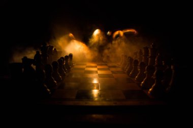 İş fikirleri ve rekabet Satranç tahtası oyun kavramı. Duman ve sis ile karanlık bir arka plan üzerinde Satranç rakamlar.