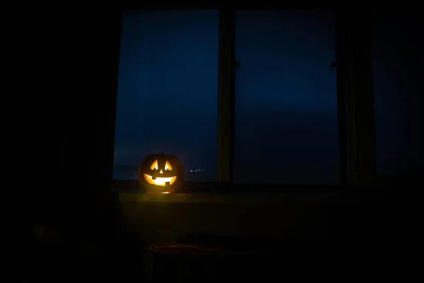 Strašidelné Halloween dýně v okně mystické domu v noci nebo halloween dýně v noci na pokoji s oknem, modrá. Symbolem Halloweenu v okně. — Stock fotografie