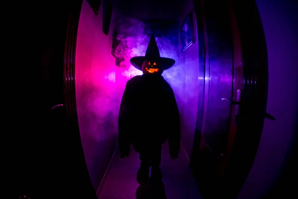 Halloween concept. Creepy silhouette in the dark corridor with pumpkin head. Toned light with fog on background. Selective focus — Stock Photo, Image