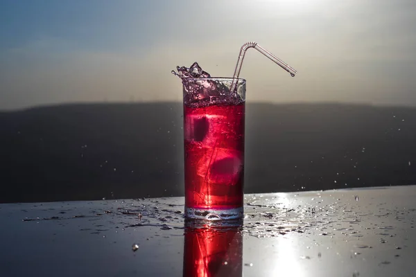 Conceito de bebida refrescante de verão. Óculos de cocktail a salpicar ao pôr-do-sol. Close up copo molhado de bebida fria no terraço . — Fotografia de Stock