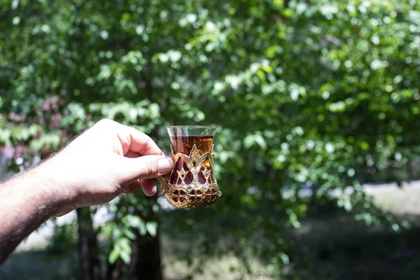 Schwarztee im Glas am Waldrand. Eastern Tea Konzept. armudu traditionelle Tasse. Hintergrund der grünen Natur. — Stockfoto
