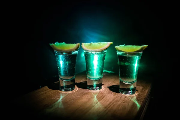 Club drank concept. Lekkere alcohol drinken cocktail Tequila met limoen en zout op levendige donkere achtergrond of glazen met Tequila in een bar — Stockfoto