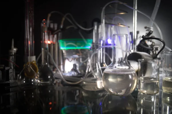Temat farmacji i chemii. Kolby szklane testowe z roztworem w laboratorium badawczym. Nauka i doświadczenie medyczne. Laboratoryjne probówki na ciemnym, stonowanym tle — Zdjęcie stockowe