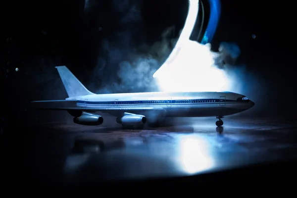 Artwork decoration. White passenger plane ready to taking off from airport runway. Silhouette of Aircraft during night time.