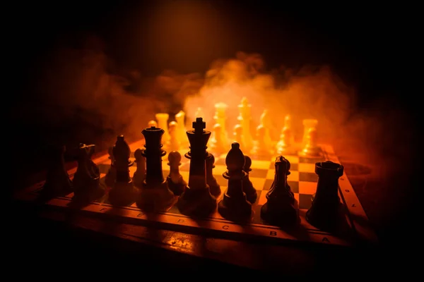 Juego de mesa de ajedrez concepto de ideas de negocio y competencia. Figuras de ajedrez sobre un fondo oscuro con humo y niebla . —  Fotos de Stock