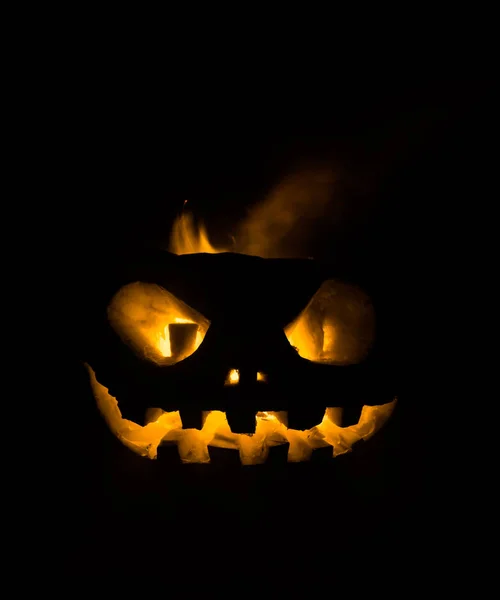 Sorriso di zucca di Halloween e occhi scarsi per la notte di festa. Vista da vicino della spaventosa zucca di Halloween con gli occhi che brillano all'interno su sfondo nero . — Foto Stock