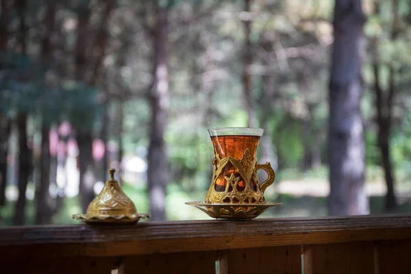 Eastern black tea in glass at the forest. Eastern tea concept. Armudu traditional cup. Green nature background. — Stock Photo, Image