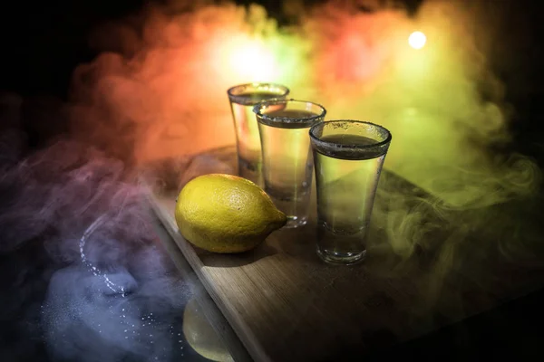 Club drank concept. Lekkere alcohol drinken cocktail Tequila met limoen en zout op levendige donkere achtergrond of glazen met Tequila in een bar — Stockfoto