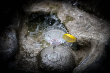 Okyanus ve palmiye ağacı arka plan ile yüzme havuzunda martini kokteyl cam. Bir bardak mavi martini kokteylhoş geldin içki barı. Seçici odak. sezon ve tatil konsepti.