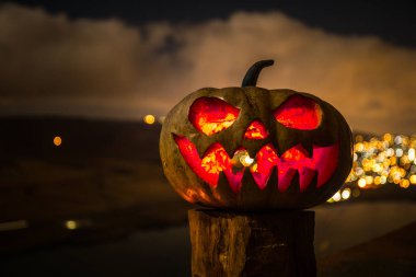 Cadılar Bayramı balkabağı gülümseme ve parti gecesi için scrary gözleri. Siyah arka planda parlayan gözleri ile korkunç Halloween kabak görünümüne yakın.