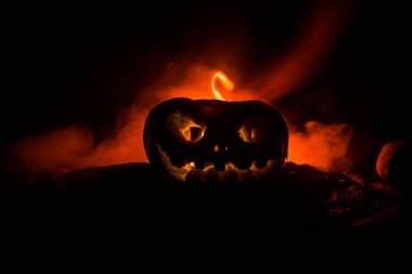 Cadılar Bayramı balkabağı gülümseme ve parti gecesi için scrary gözleri. Siyah arka planda parlayan gözleri ile korkunç Halloween kabak görünümüne yakın.