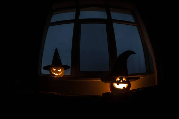 Gruseliger Halloween-Kürbis in der Nacht im mystischen Hausfenster oder Halloween-Kürbis in der Nacht auf Zimmer mit blauem Fenster. Symbol von halloween im Fenster. — Stockfoto