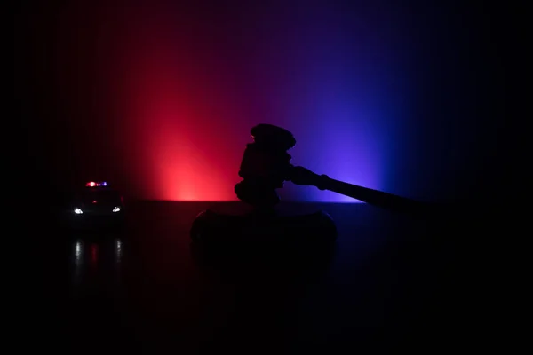 법률 법률 개념입니다. 안개 배경에서 깜박이 빨간색과 파란색 경찰 불 뒷면에 정의의 동상과 수 갑의 실루엣. 선택적 초점 — 스톡 사진