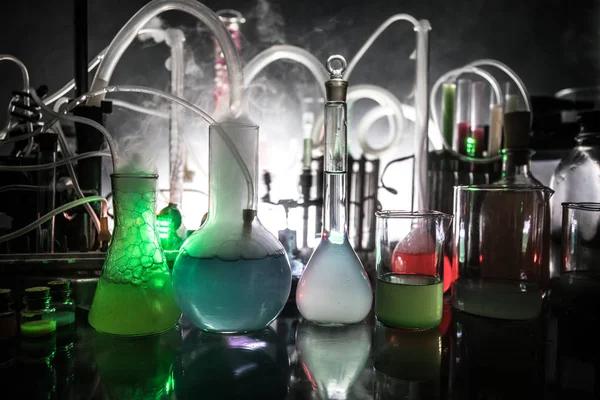 Pharmacy and chemistry theme. Test glass flask with solution in research laboratory. Science and medical background. Laboratory test tubes on dark toned background