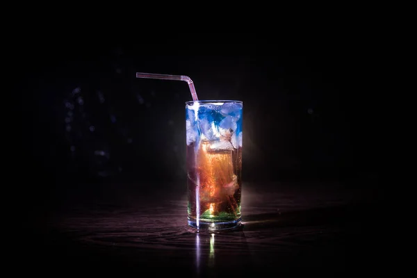 Cocktail glass splashing on dark toned smoky background or colorful cocktail in glass. Party club entertainment. Mixed light. — Stock Photo, Image