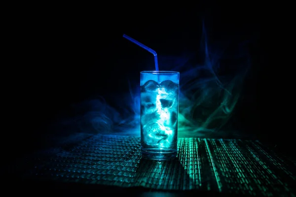 Cocktailglas auf dunkel getöntem, rauchigen Hintergrund oder farbenfroher Cocktail im Glas. Party Club Unterhaltung. gemischtes Licht. — Stockfoto