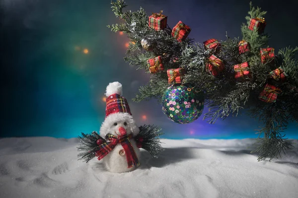 La decoración Navideña - la chuchería sobre la rama del pino con los atributos de fiesta sobre la nieve. Enfoque selectivo — Foto de Stock