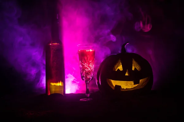 Deux verres de vin et une bouteille avec Halloween - vieux Jack-o-lanterne sur fond sombre et brumeux. effrayant Halloween citrouille — Photo