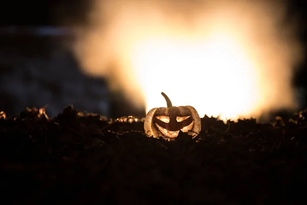 Halloween jack-o-linterna en hojas de otoño. Calabaza de Halloween asustadiza mirando a través del humo. Brillante , —  Fotos de Stock