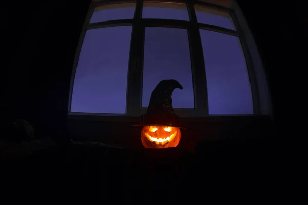 Abóbora de Halloween assustadora na janela mística da casa à noite ou abóbora de Halloween à noite no quarto com janela azul. Símbolo de Halloween em janela . — Fotografia de Stock