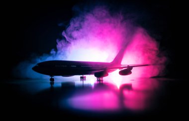 Sanat dekorasyonu. Beyaz yolcu uçağı havaalanı pistinden kalkışa hazır. Gece saatlerinde Uçak Silueti.