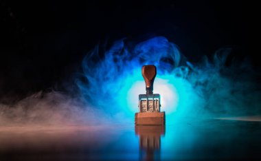 Koyu tonda sisli arka plan ile ahşap masa üzerinde kauçuk tarih damgası yakından görünümü.