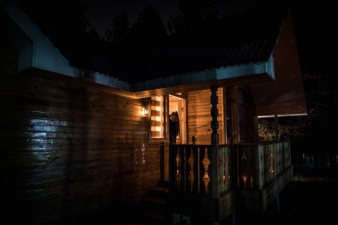 Geceleri ormanda bir hayaletin olduğu eski bir ev ya da sis içinde terk edilmiş bir korku evi. Ölü ağaç ormanındaki eski mistik bina. Geceleri aylı ağaçlar. Gerçeküstü ışıklar. Korku Cadılar Bayramı konsepti